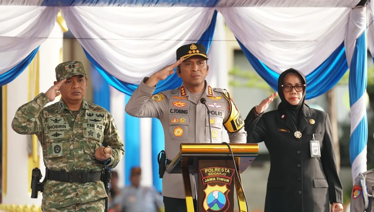 Kapolresta Sidoarjo memberikan arahan di atas mimbar dengan barisan personel di belakangnya.